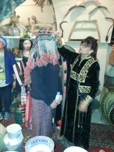 Host demonstrating how a headwear for females would be worn.